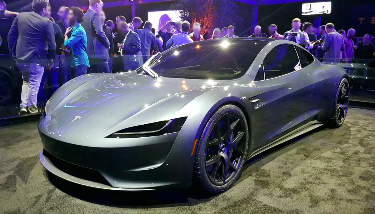 A silver Tesla Roadster prototype on display at its November 2017 launch event, with a crowd of people standing behind it
